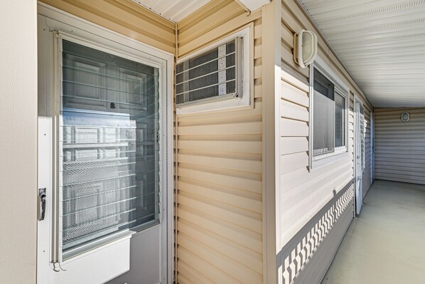 A corridor with sliding glass doors and windows, a ceiling vent, and a white exterior wall. - 2 Blocks to Beach & Boardwalk: Ocean City Condo (Ocean City)