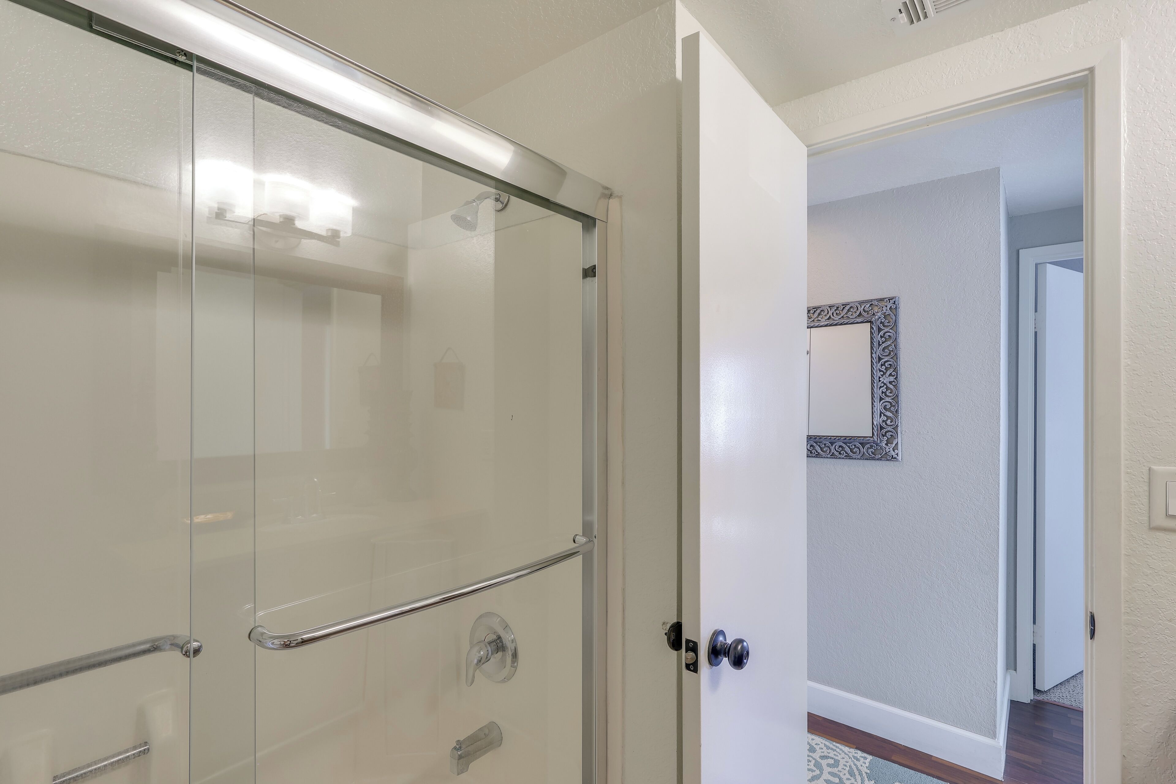 Une douche entièrementClose avec une paroi en verre, une poignée en métal et une porte en verre.