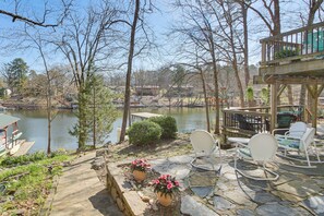A lakeside patio with stone flooring, potted plants, and outdoor furniture. - Tranquil Family Retreat w/ Views on Lake Desoto (Hot Springs Village)
