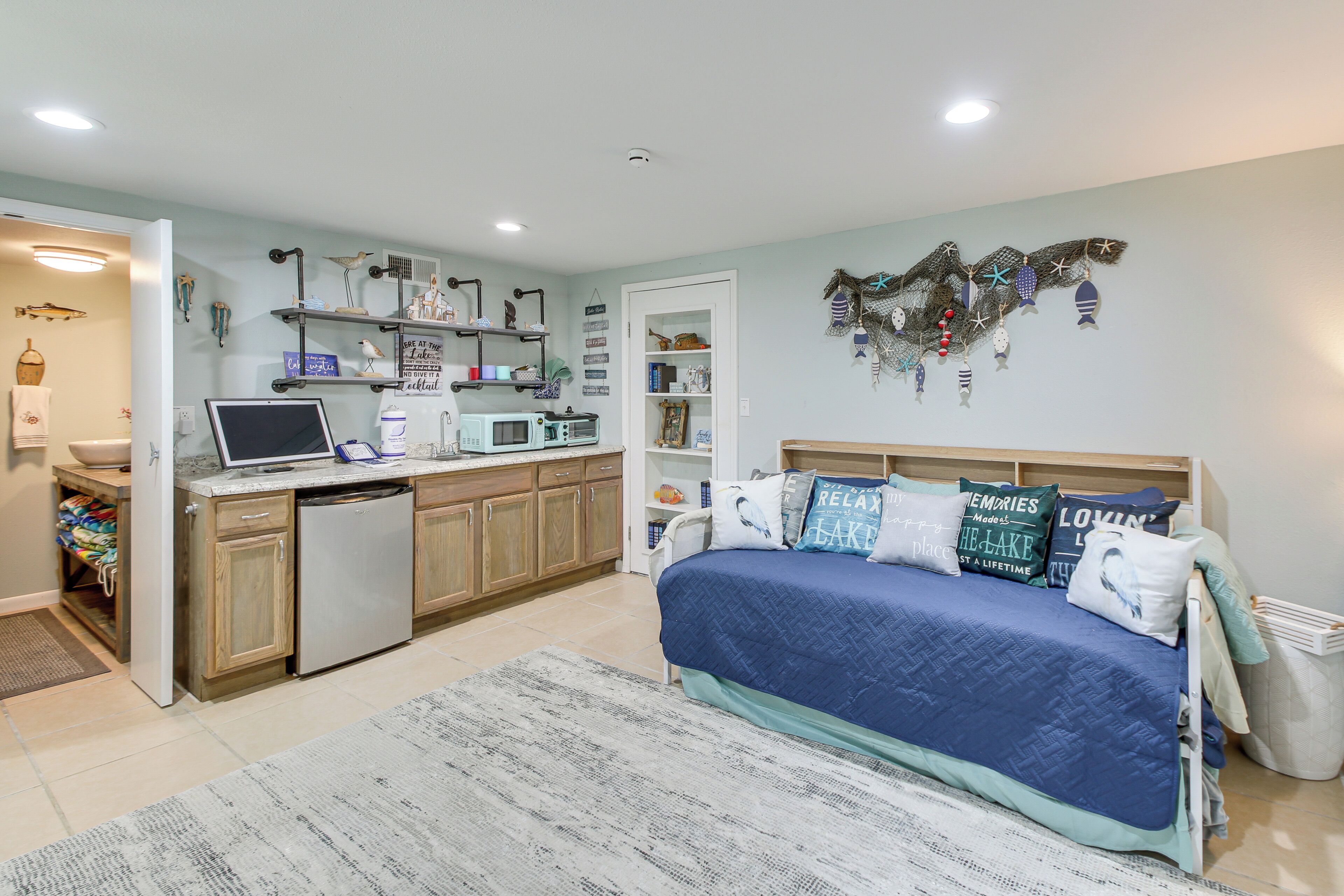 Un dormitorio con cama, escritorio y kitchenette.