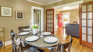 A dining area with a round table set for four, surrounded by wooden chairs. - Pet-friendly 'railroad Cottage' Near Wedowee Lake (Lineville)