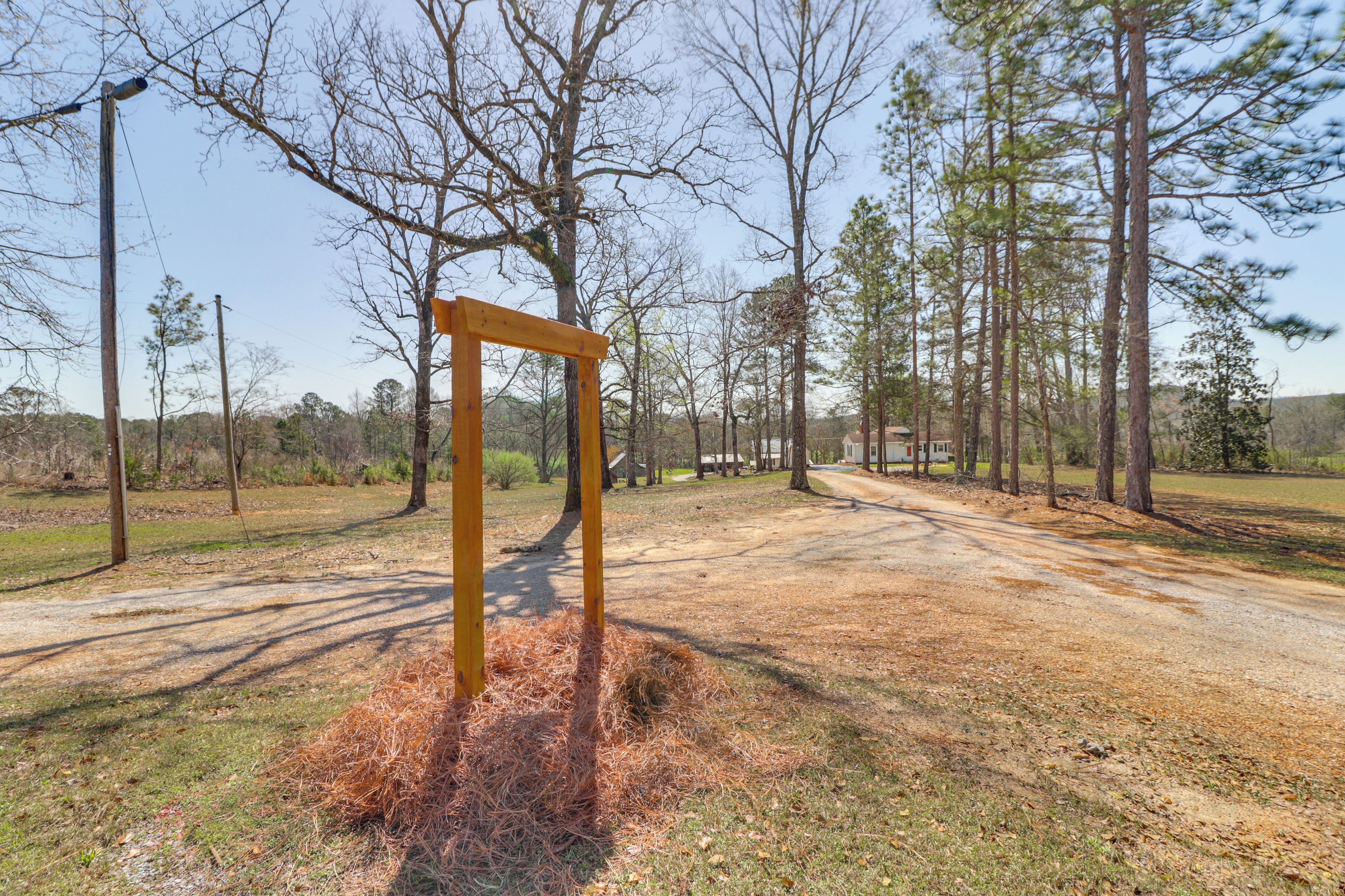 A wooden structure in a natural setting with trees and a dirt path.