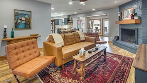 A living room with a sofa, armchair, coffee table, and fireplace. - Gorgeous Lakefront Home w/ Chef's Outdoor Kitchen (Mabank)