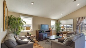 A living room with a sofa, a coffee table, a TV, and plants. - Fish, Play & Explore! Family Gem in Rural Richland (Richland)