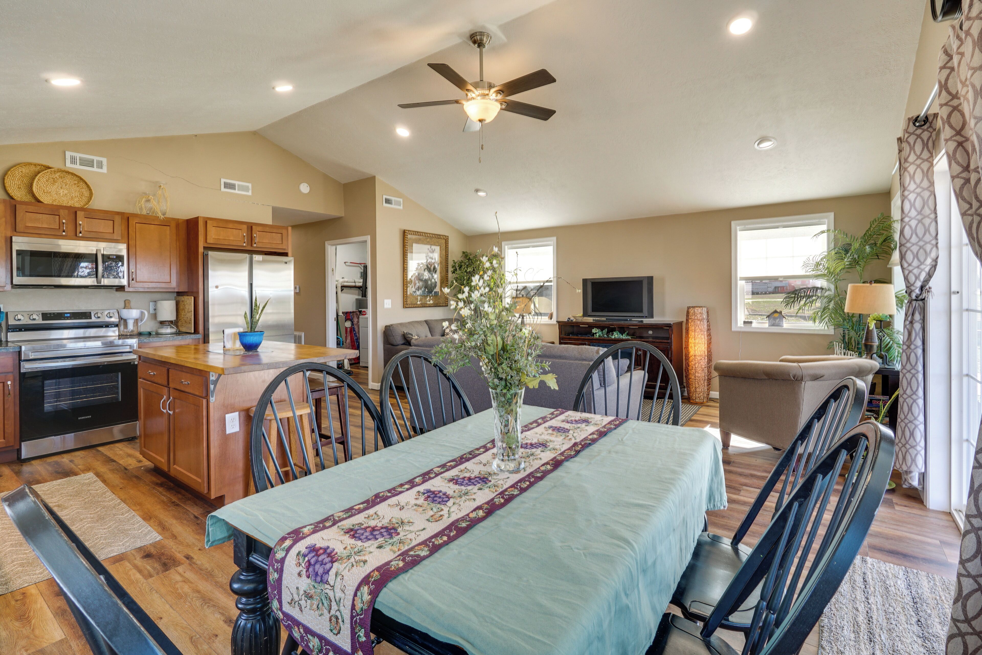A spacious living area with a dining table, kitchen, and seating area.