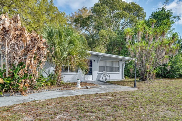 A small, single-story house with a front yard, a white exterior, and a visible window. - Peaceful Home Near Cape Canaveral & River! (Mims)