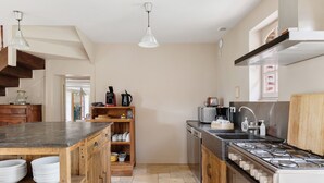 A kitchen with wooden cabinets, a stove, a sink, and a countertop.