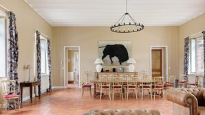 Ein geräumiges Wohnzimmer mit Essbereich, einer Kristallleuchtre und einem großen Gemälde eines Stiers an der Wand.