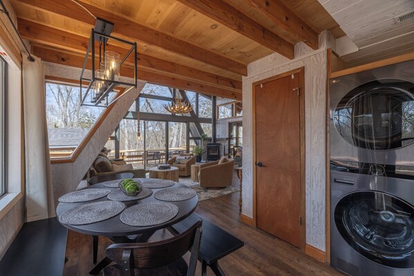 Een modern interieur met een eethoek, een trap en een groot was-droogcombinatie.