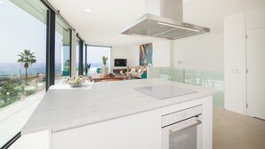 A modern kitchen with a large island, a built-in oven, and a view of the ocean. - Lux 200m NEW D Villa with heated pool, ocean view (Costa Adeje)