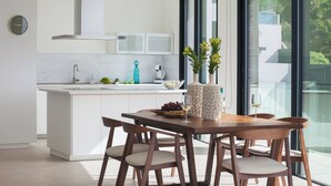 A modern kitchen with a central island, white cabinetry, and a large window offering a view of greenery. - Lux 200m NEW D Villa with heated pool, ocean view (Costa Adeje)