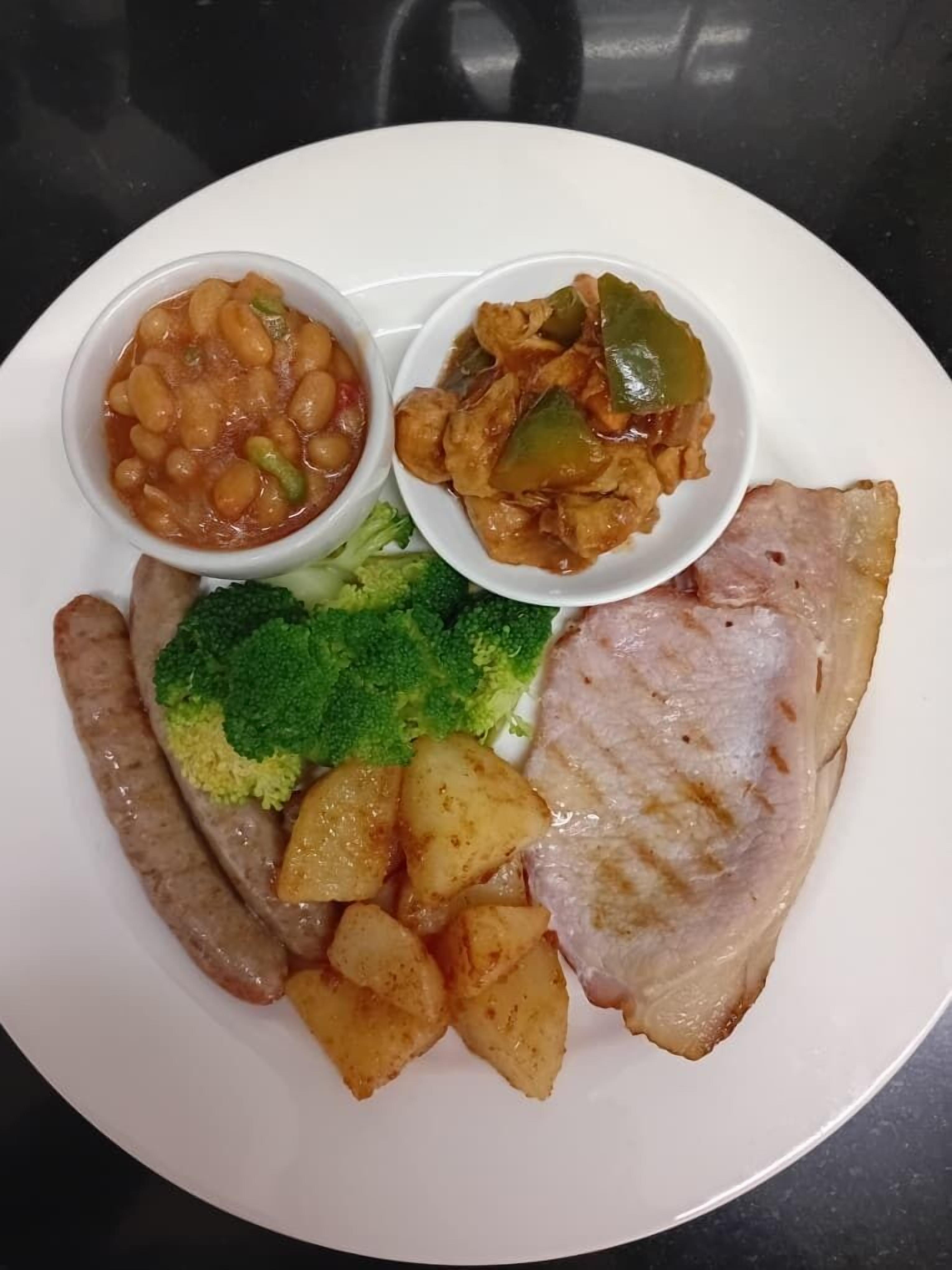 A plate with food items including beans, chicken, broccoli, potatoes, and a piece of meat.