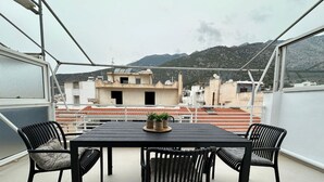 A balcony with a table and chairs, overlooking a mountainous landscape. - Loutraki s Hideaway in Loutraki (Loutraki-Agioi Theodoroi)