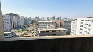 A cityscape with high-rise buildings, a clear sky, and a view from a balcony. - Luxury Oasis: 2-bedroom apartment w/ downtown city views (Addis Ababa)