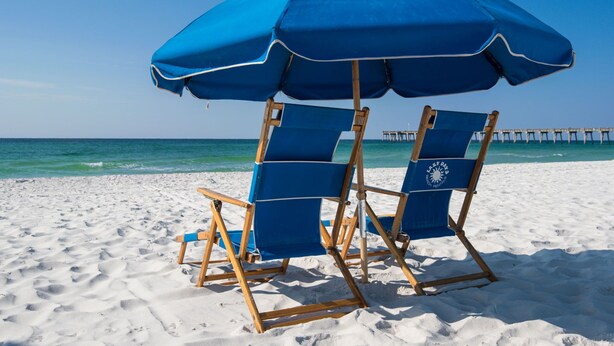 A beach with two blue beach chairs and a matching umbrella. - Family Friendly Pensacola Home Near Gulf Breeze (Pensacola)