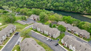 A residential area with a river, houses, and a parking lot. - Pr66-8 4 Bedroom Condo (Branson)