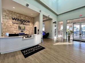 A reception area with a brick wall, a reception desk, and a sign that reads 'Windsor Island Resort.' - New Listing! Windsor Island-2166 8br · Disney 8 Bedroom Home (Davenport)