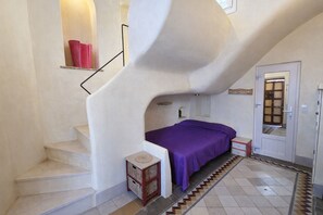 A bedroom with a bed, a nightstand, a dresser, a staircase, and a door with a window. - Patio del Azahar Conil con Terraza (Conil de la Frontera)