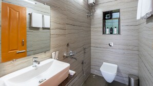 Ein Badezimmer mit Waschbecken, Spiegel, Dusche und Toilette.