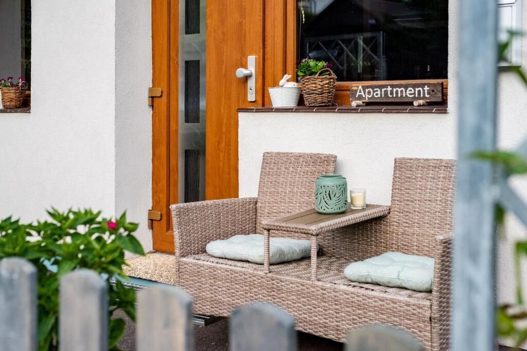 Wicker meubels, een klein tafeltje en een bordje dat een appartement aangeeft.
