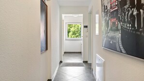 A hallway with a view of a window, a door, and a wall-mounted picture. - Rural, Quiet Apartment (Rosengarten)