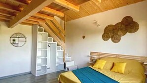 Une chambre à coucher avec un lit, un escalier et une étagère fixée au mur.