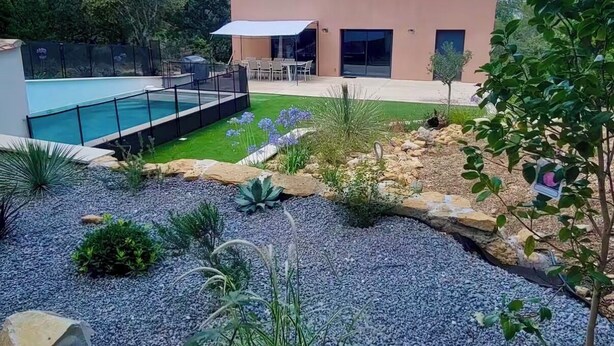 Une maison moderne dotée d’une piscine, d’une terrasse et d’un jardin bien entretenu.