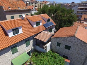 A residential area with terracotta-tiled roofs, stone buildings, and green shutters. - Apartment and Rooms Desideria (Split)