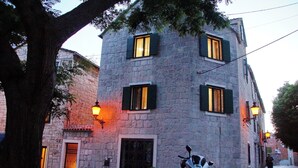 Un bâtiment en pierre doté de nombreuses fenêtres, d’une porte et d’un lampadaire.