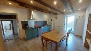 Una cocina con una mesa y sillas de madera, un microondas y un lavamanos.