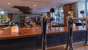 Eine moderne Hotelhalle mit Barbereich, Sitzgelegenheiten und einem Billardtisch.