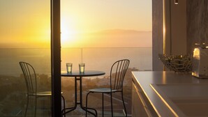 A balcony with a table and chairs, overlooking a body of water during sunset. - Lux 250m NEW Villa E with heated pool, ocean view (Costa Adeje)