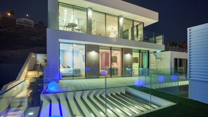 A modern multi-story house with glass balconies, a staircase, and a view of the surrounding landscape. - Lux 250m NEW Villa E with heated pool, ocean view (Costa Adeje)