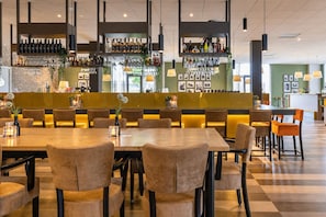 A restaurant with a bar area, multiple seating options, and a checkered floor. - Sittard Wellness Stay – Cozy Rooms with Access to Spa, Gym & Sauna - 3 Units (Sittard)