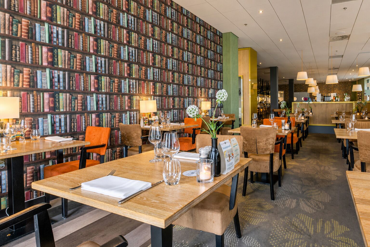 Un restaurant aménagé comme une bibliothèque, avec des étagères, des tables et des chaises.