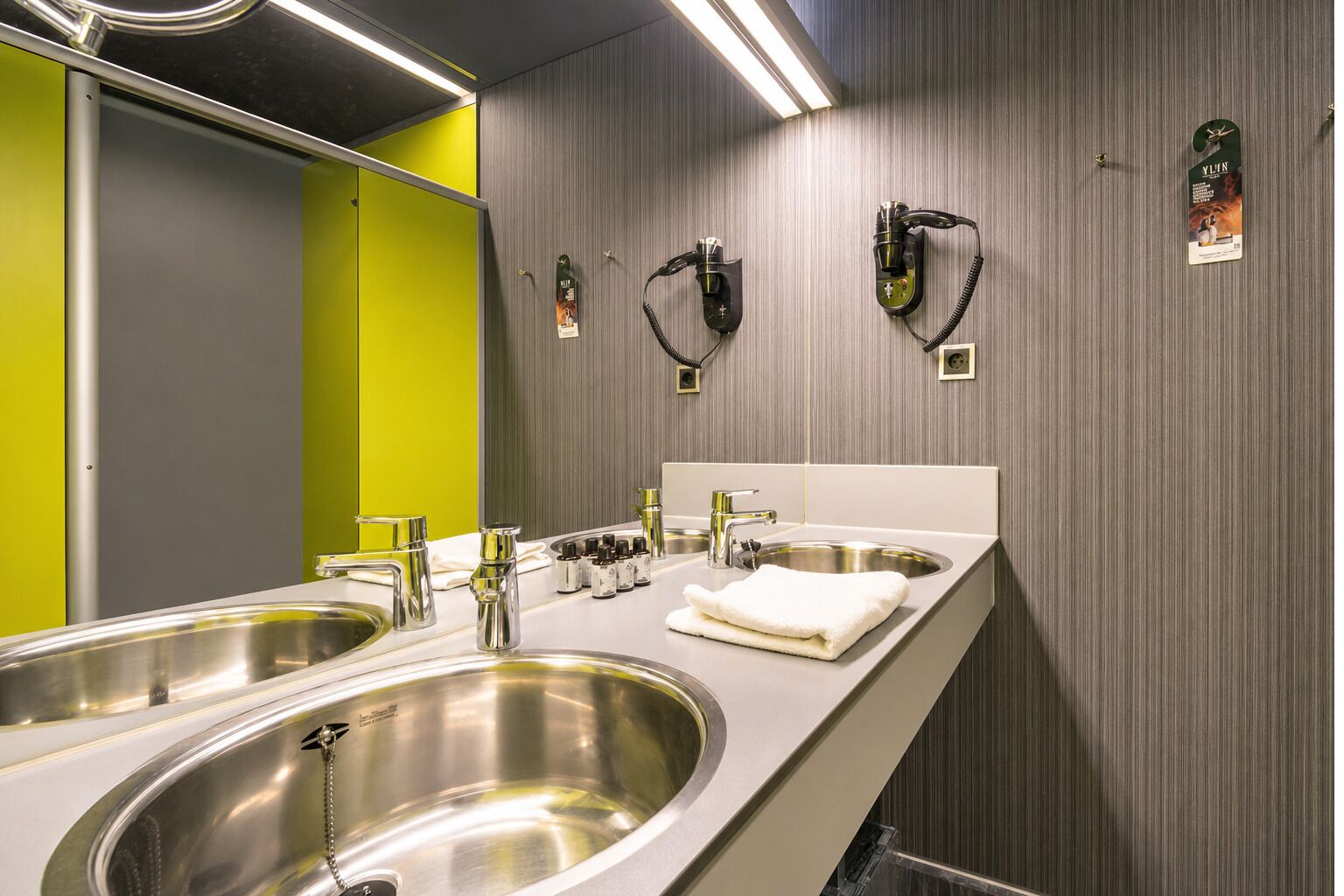 Un baño moderno con dos lavamanos, un espejo y un perchero para toallas.