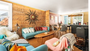Una sala de estar con sofá, mesa de centro y una zona de comedor con sillas y mesa.