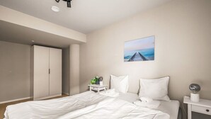 Un dormitorio con cama, mesita de noche, un cuadro en la pared y un armario.