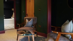 A room with a wooden door, a chair with a cushion, a glass table, and a carpeted floor.