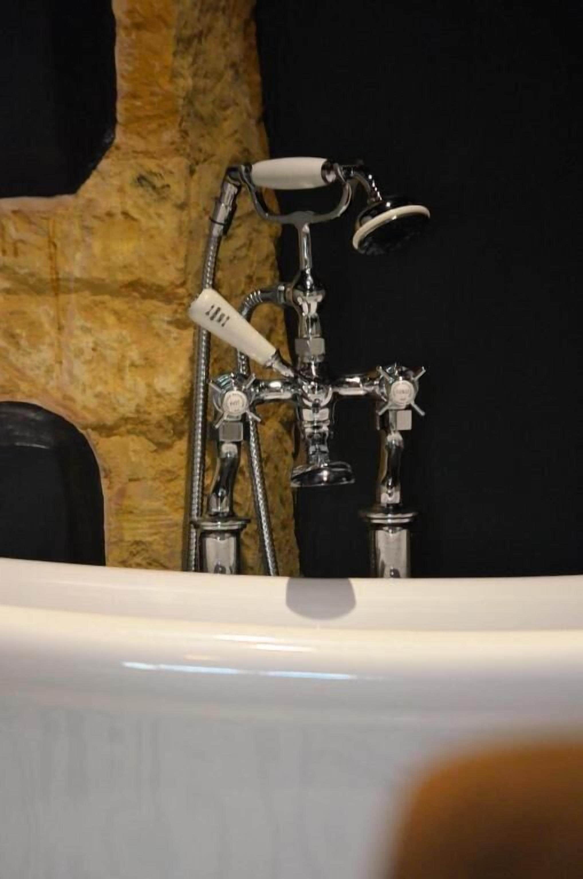 A bathroom with a bathtub, a shower, and a hand shower.