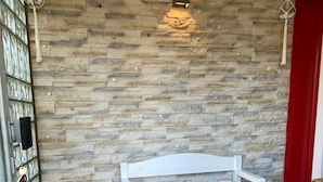 A white bed in a room with a stone wall and wooden flooring. - BergZeit Karles | Winterberg—Your Favorite Spot on the Rothaarsteig•Ski•Hiking•Bike Park (Winterberg)