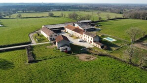 An aerial view of a farm with multiple buildings, a swimming pool, and surrounding green fields. - The Large La Bredanchère Cottage (Lathus-Saint-Rémy)