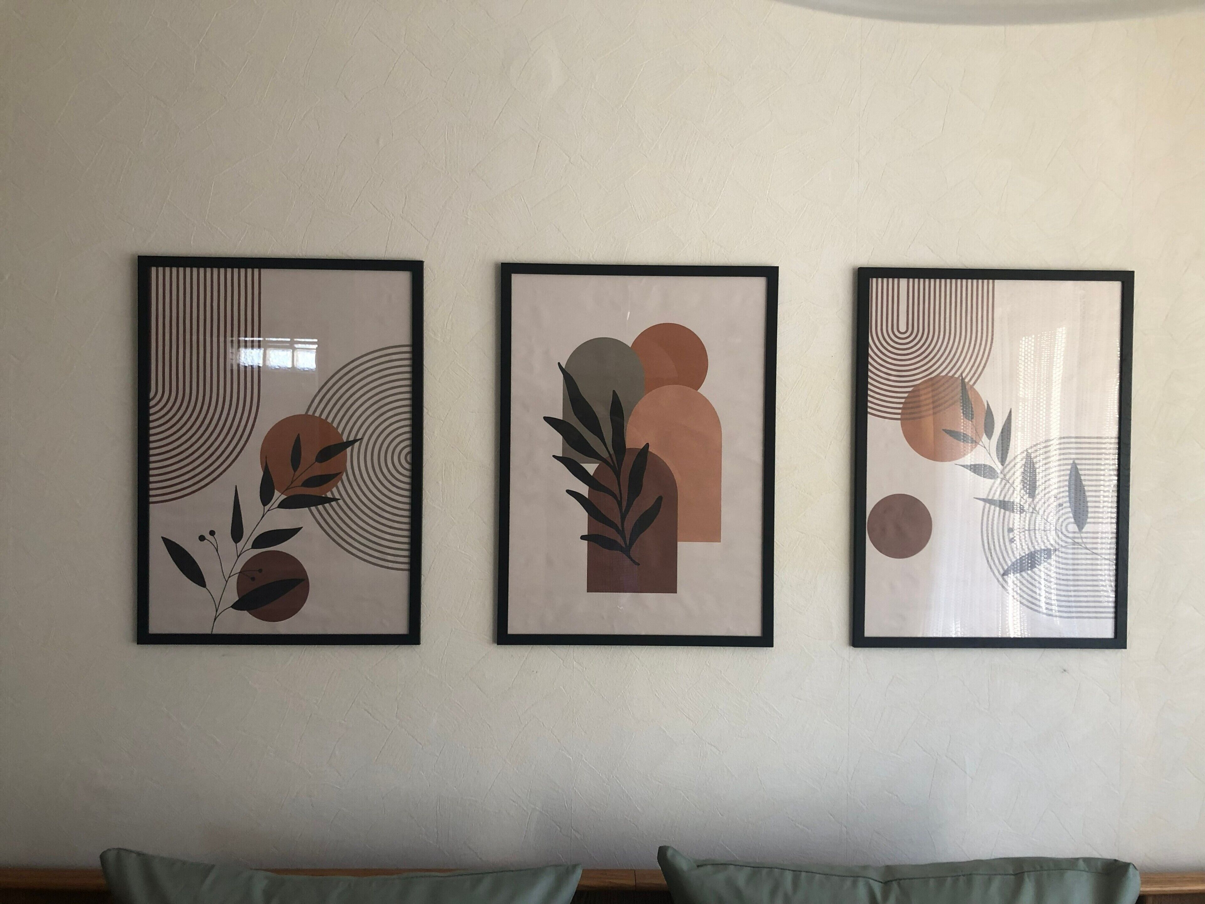 Three framed abstract artworks on a wall.
