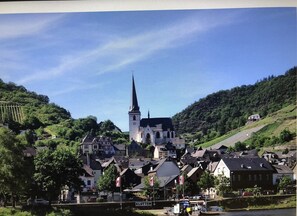 A town with a prominent church, traditional houses, and a river. - Room 'Zimmer 3D, Antik 2og' with Shared Garden, Balcony and Wi-Fi (Klotten)