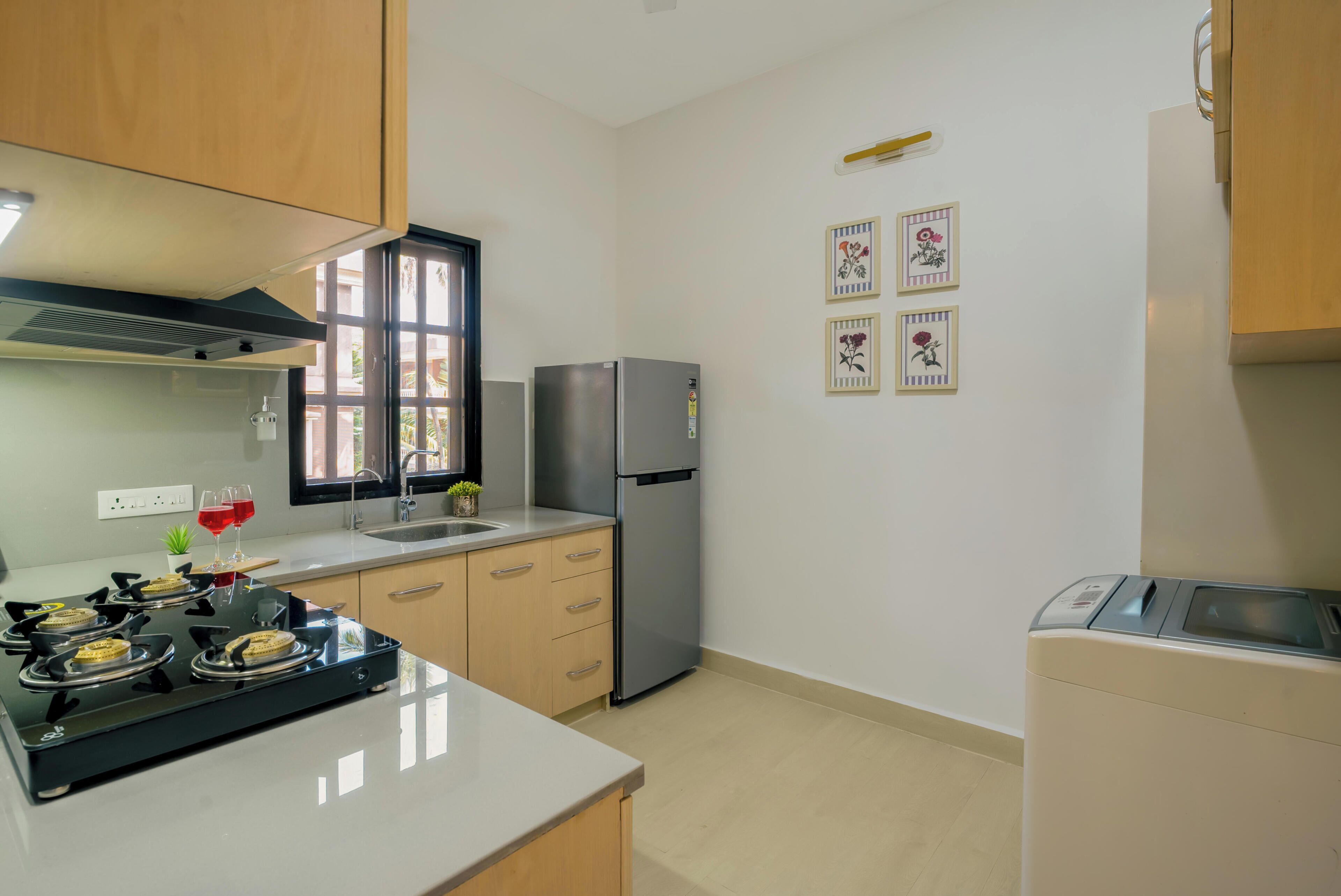 A modern kitchen with a stove, refrigerator, and sink.