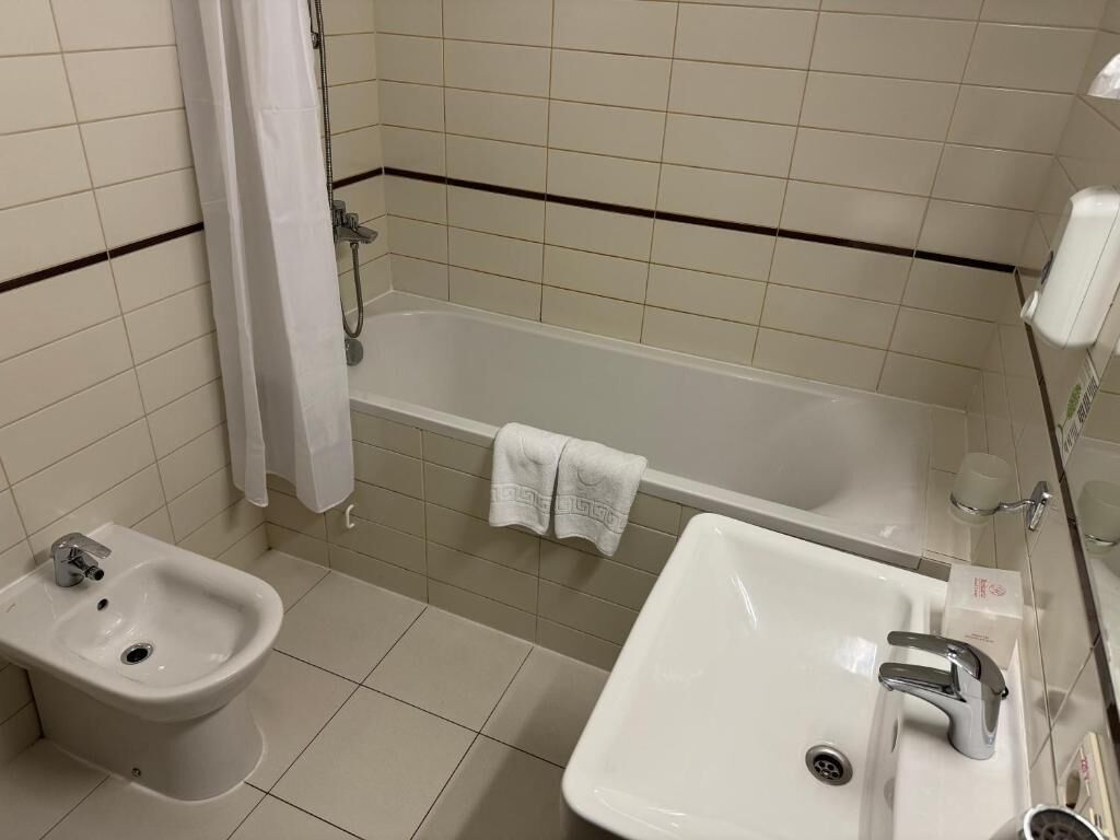Un baño con bidé, lavamanos y bañera.