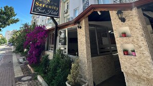 A szálloda bejárata, amelyen egy tábla jelzi: „Serenity Suite Hotel”.