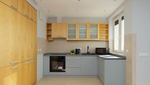 A modern kitchen with grey cabinets, a microwave, and a sink. - Spacious Apartment with a Balcony | A Place to Work (Warszawa)