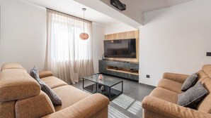 A modern living room with a sofa set, a flat-screen TV, and a glass coffee table. - Modern Apartment Larisa in Tar with Pool for 4 (Tar)
