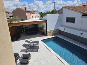 A swimming pool with lounge chairs and a barbecue area. - Modern Apartment Larisa in Tar with Pool for 4 (Tar)